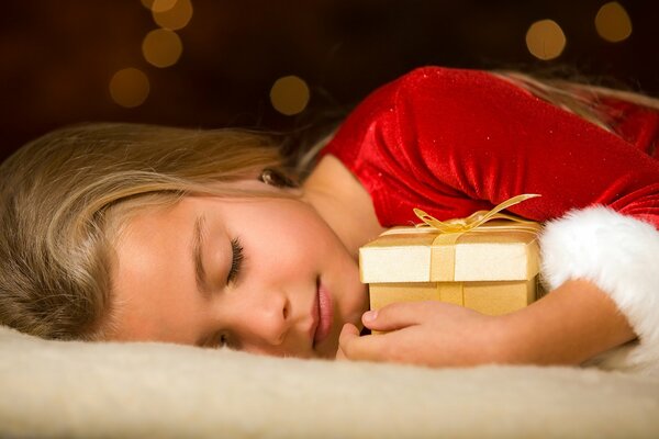 Sleeping girl hugs a gift