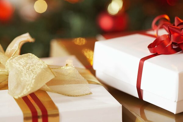 White gift boxes with red and beige ribbons