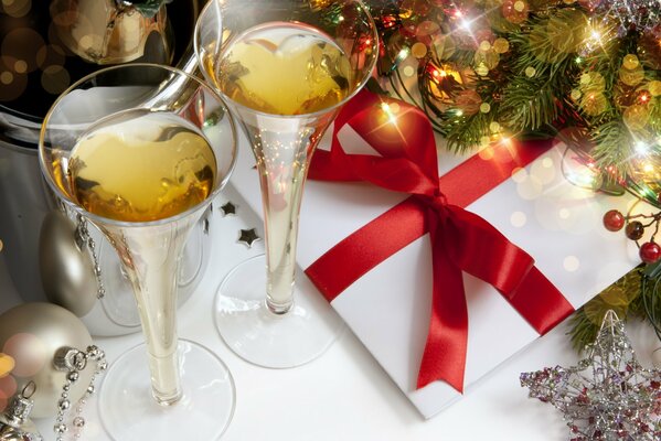 Champagne dans les verres, cadeau de Noël et arbre de Noël