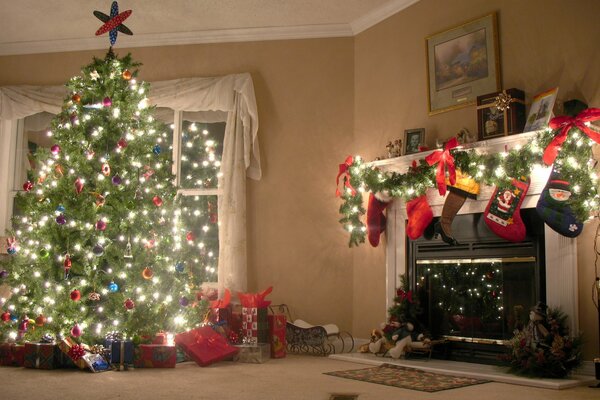 Árbol de Navidad vestido cerca de la chimenea con regalos