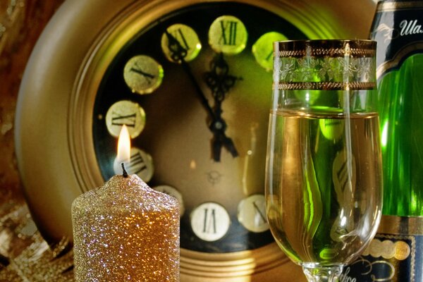 Kieliszek szampana, świeca, zegar-oczekiwanie na Nowy Rok