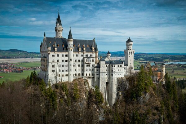 Panorama of Neuschwanschein Castle. Cloudy sky over the field