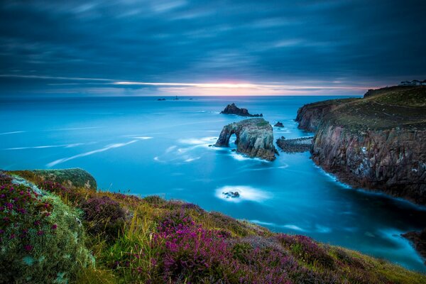 There is a blue sea on the coast of the cliff