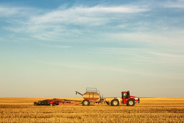 Tracteur sur fond de champ jaune et ciel bleu