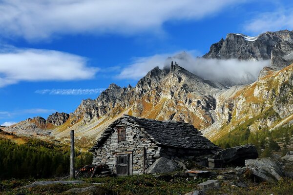 Wolken am blauen Himmel über den Berghängen