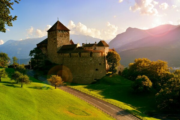 Schloss an der Straße in den Alpen vor dem Hintergrund der Berge
