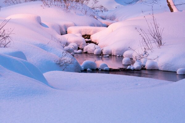 Ruscello in enormi cumuli di neve