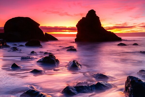 Piękny zachód słońca na brzegu z kamieniami