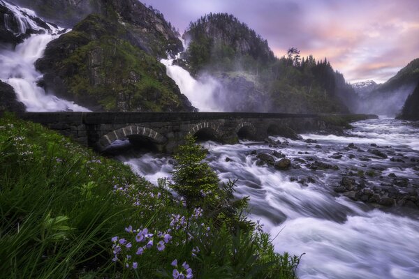 Norwegian waterfall flowing under the bridge