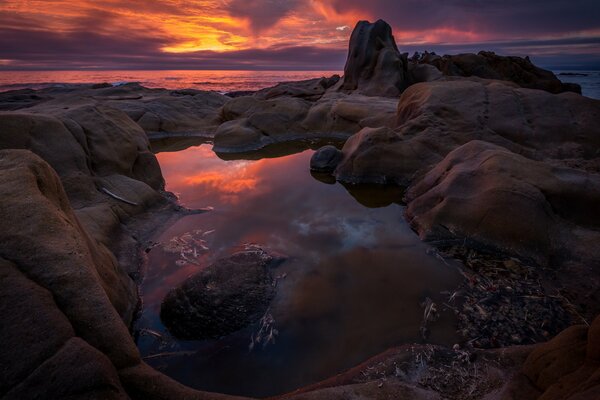 Sunset on the background of rocks and ocean