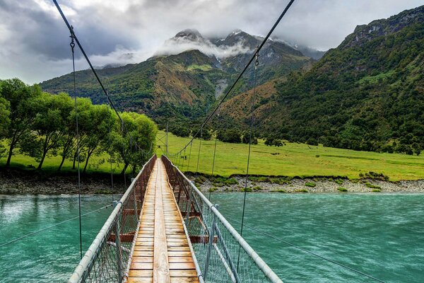 Puente oscilante sobre el río. Camino a las montañas