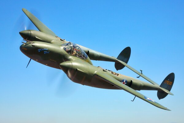 A big heavy fighter jet is flying in the blue sky