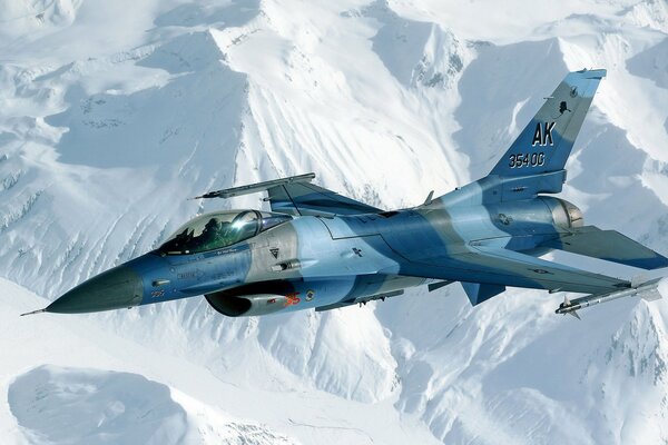 A fighter in the sky flies over the snowy mountains