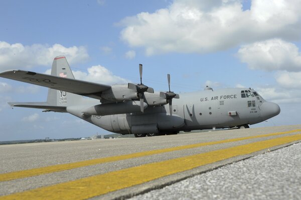 At the airbase, an American c-130 aircraft is preparing to take off from the airfield