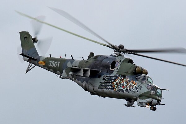 Flying Military transport Mi-35 on a gray sky background