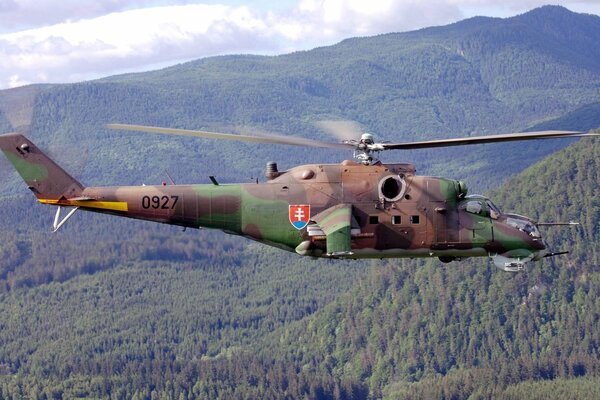 Un hélicoptère de combat mi-24 survole les arbres