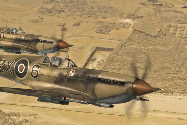 Aereo Spitfire nel deserto sullo sfondo delle piramidi