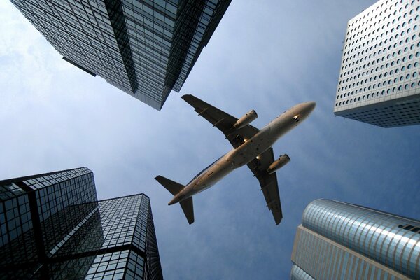 A plane flying directly over a skyscraper