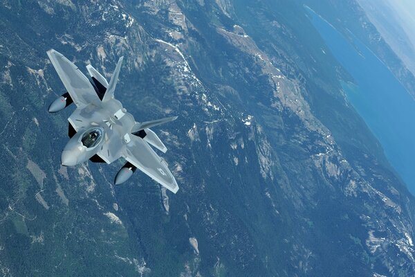 Avión de combate F22 Raptor de la fuerza aérea de los Estados Unidos en el cielo sobre la costa