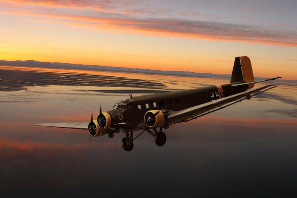 Junkers allemand à trois moteurs sur fond de coucher de soleil