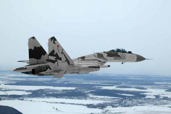 A fighter in flight over a winter field