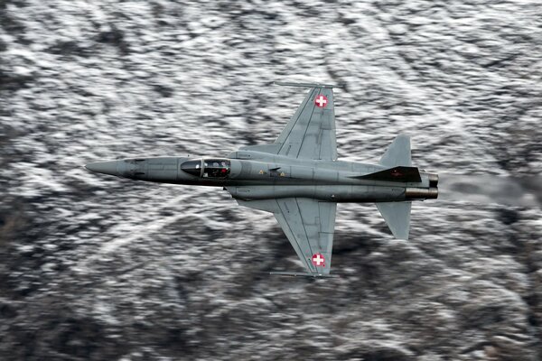 The F5E fighter is flying over the sea