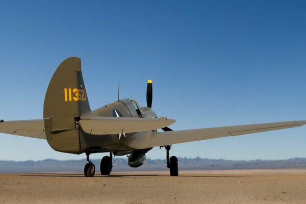 A plane in the desert against the background of mountains in the distance