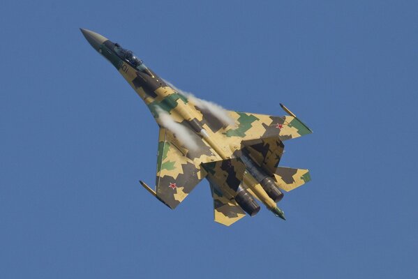 Chasseur su-35s vole dans le ciel bleu