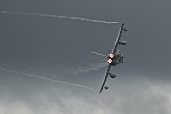 A plane making a turn against a gray sky