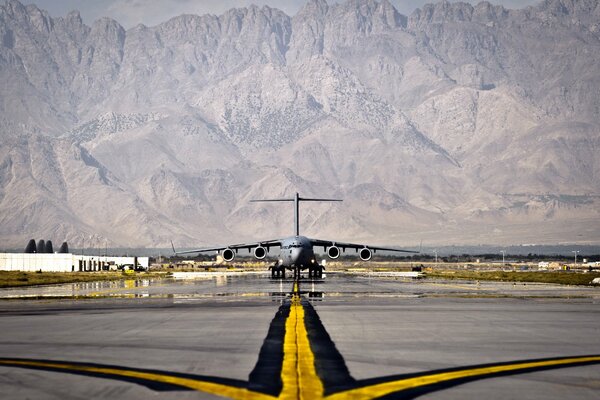 Avion sur la piste sur fond de montagnes