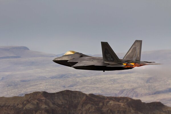 Avión militar Raptor en el cielo sobre las montañas