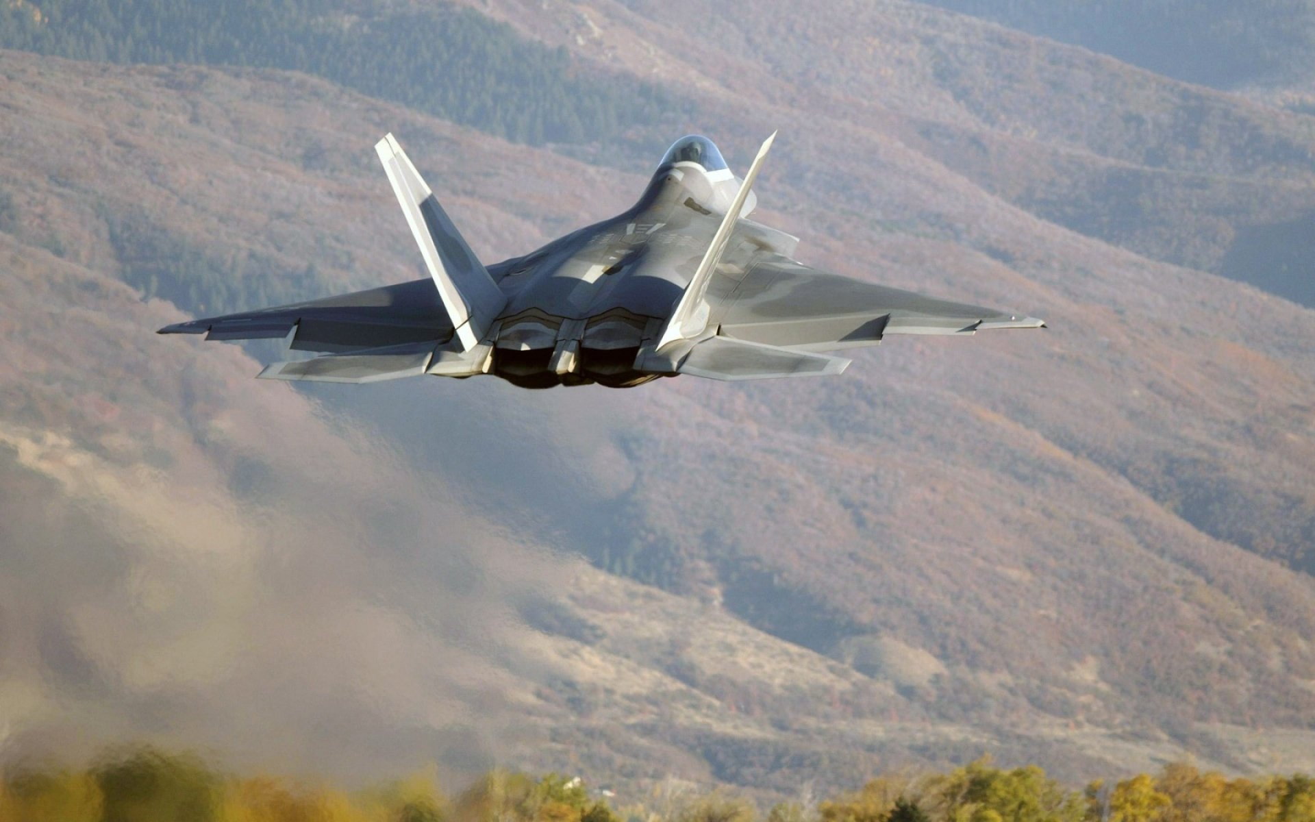 lockheed / boeing f-22 raptor mehrzweck kämpfer fünfte generation fliegen bäume berge hügel abheben foto