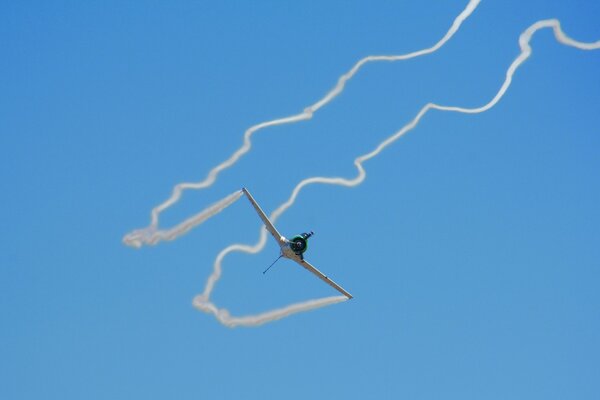 Flugzeug am blauen Himmel mit Schwanz aus Rauch