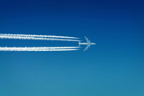 El avión que deja atrás un casco blanco como la nieve en el cielo