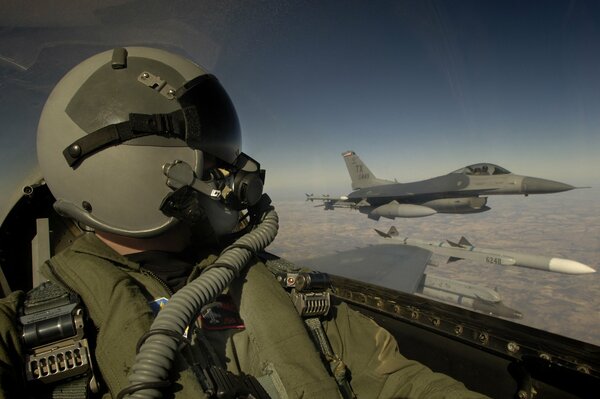 A military plane is flying above the clouds