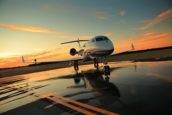 Schöner Sonnenuntergang vor dem Hintergrund des Flugzeugs und des Flugplatzes