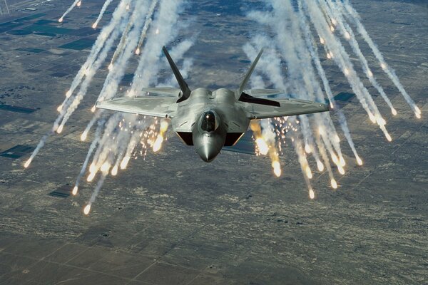 F-22 sur fond de terre jette des pièges thermiques