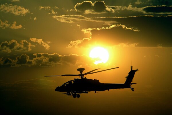 Apache helicopter in the light of the sun at sunset