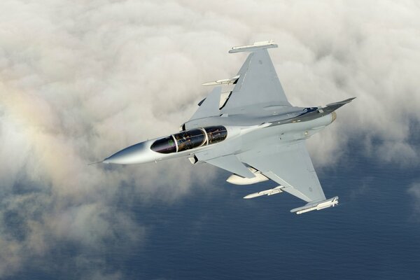 A fighter jet flies in the sky and flies a rainbow