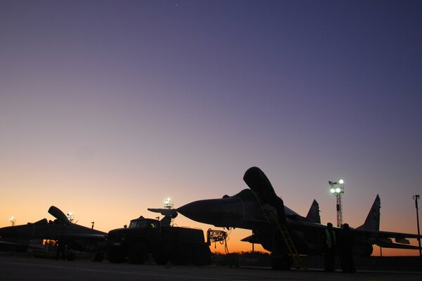 Mig-29 fighters stand at the airfield at sunset