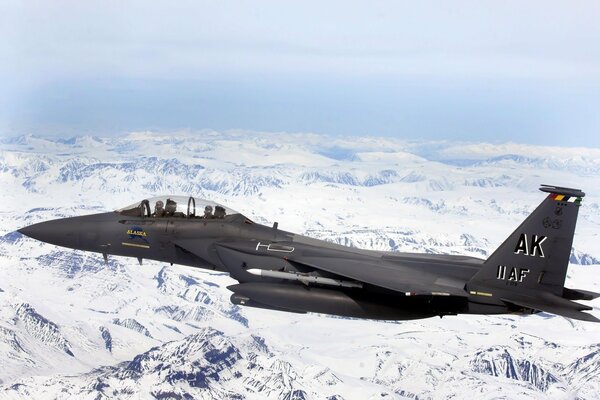 A fighter on a low-level flight over snowy mountains