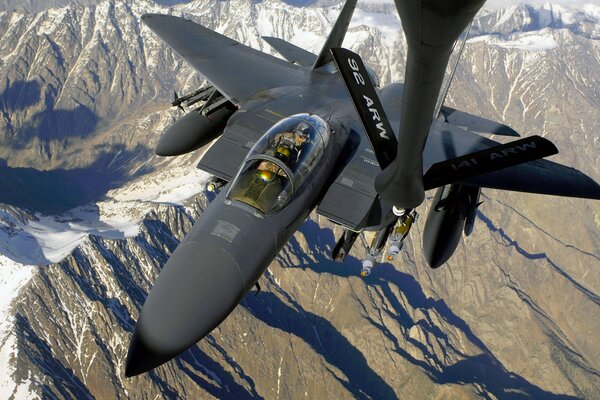 Rifornimento di carburante di aerei militari, foto di montagne dalla cabina di pilotaggio del combattente