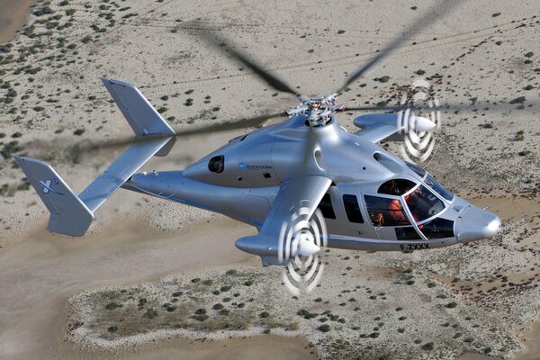 Vol d un avion à voilure tournante au-dessus du désert