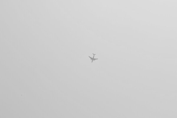 Samolot wysoko na szarym niebie