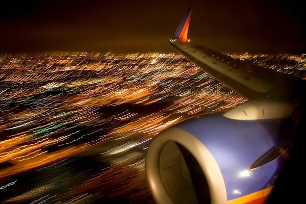 Ala dell aereo nella città di notte