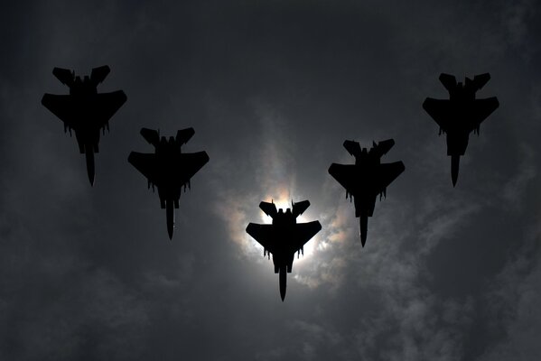 Пять боевых самолётов в полете в темном вечернем небе