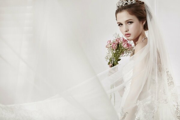 Bride with tiara and veil on a light background