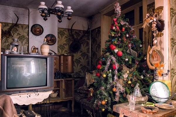 Geschmückter Weihnachtsbaum vor dem Fernseher im Zimmer