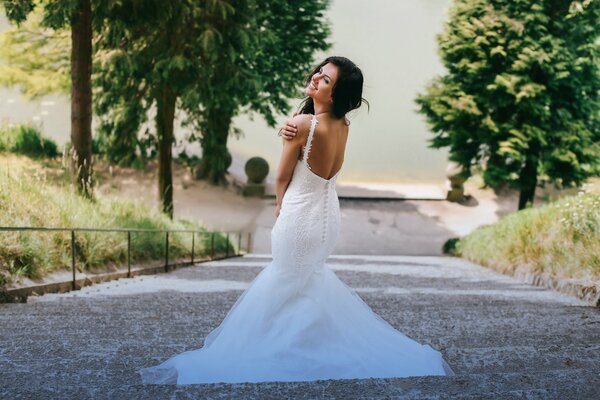 Ragazza in un bellissimo abito da sposa con la schiena aperta