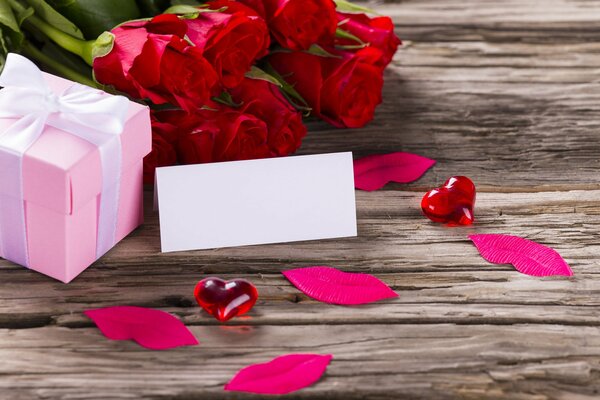 Pink gift box with white ribbon and red roses